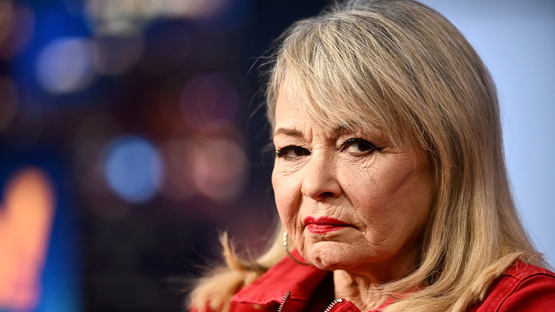 Roseanne Barr with blonde hair and a red jacket looking mean on Gutfeld!