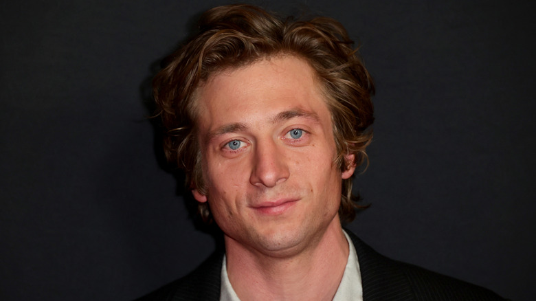 Jeremy Allen White posing in front of a dark grey background
