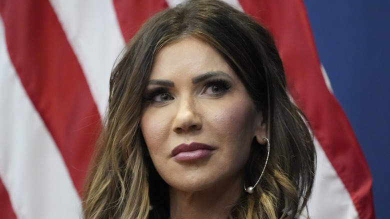 Wearing foundation-heavy makeup, Kristi Noem looks away from the camera.
