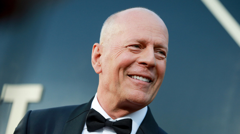 Actor Bruce Willis smiling and looking to the side on the red carpet