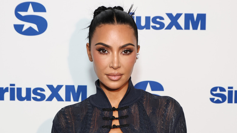 Kim Kardashian poses in 2025, looking into the camera with a slight smile