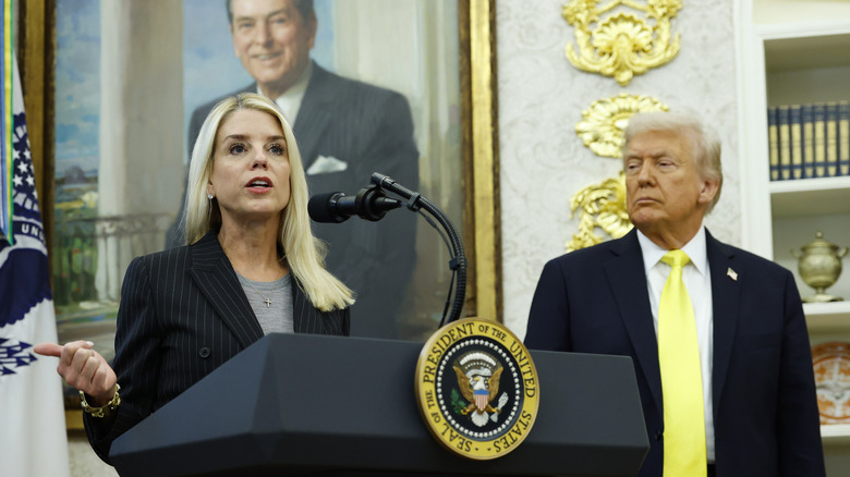 Donald Trump looking at Pam Bondi as she speaks at a podium