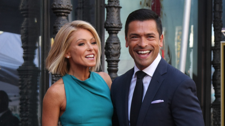 Kelly Ripa and Mark Consuelos posing outdoors